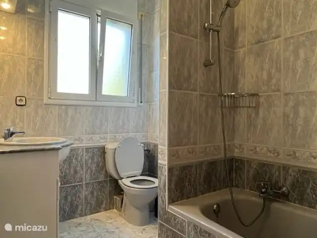 Badezimmer 3. Wohnung 2 hat ein Badezimmer mit Waschbecken, Toilette, Badewanne und Dusche.