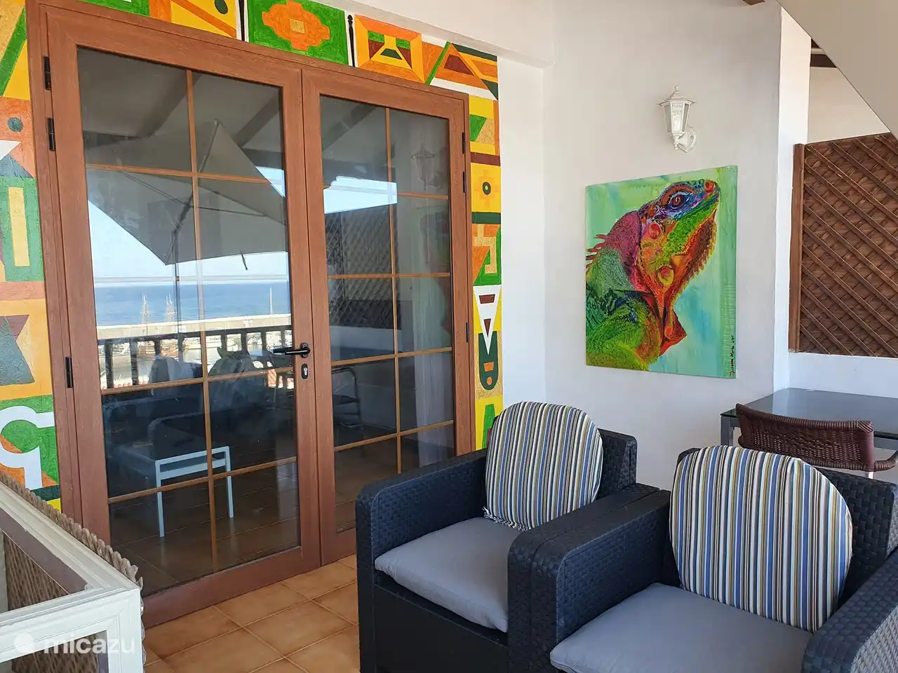 balcón con cómodos asientos, mesa y 2 montantes exteriores