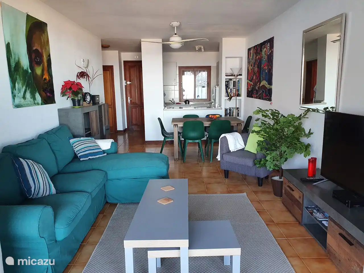 salón con zona de estar, mesa de comedor y cocina abierta