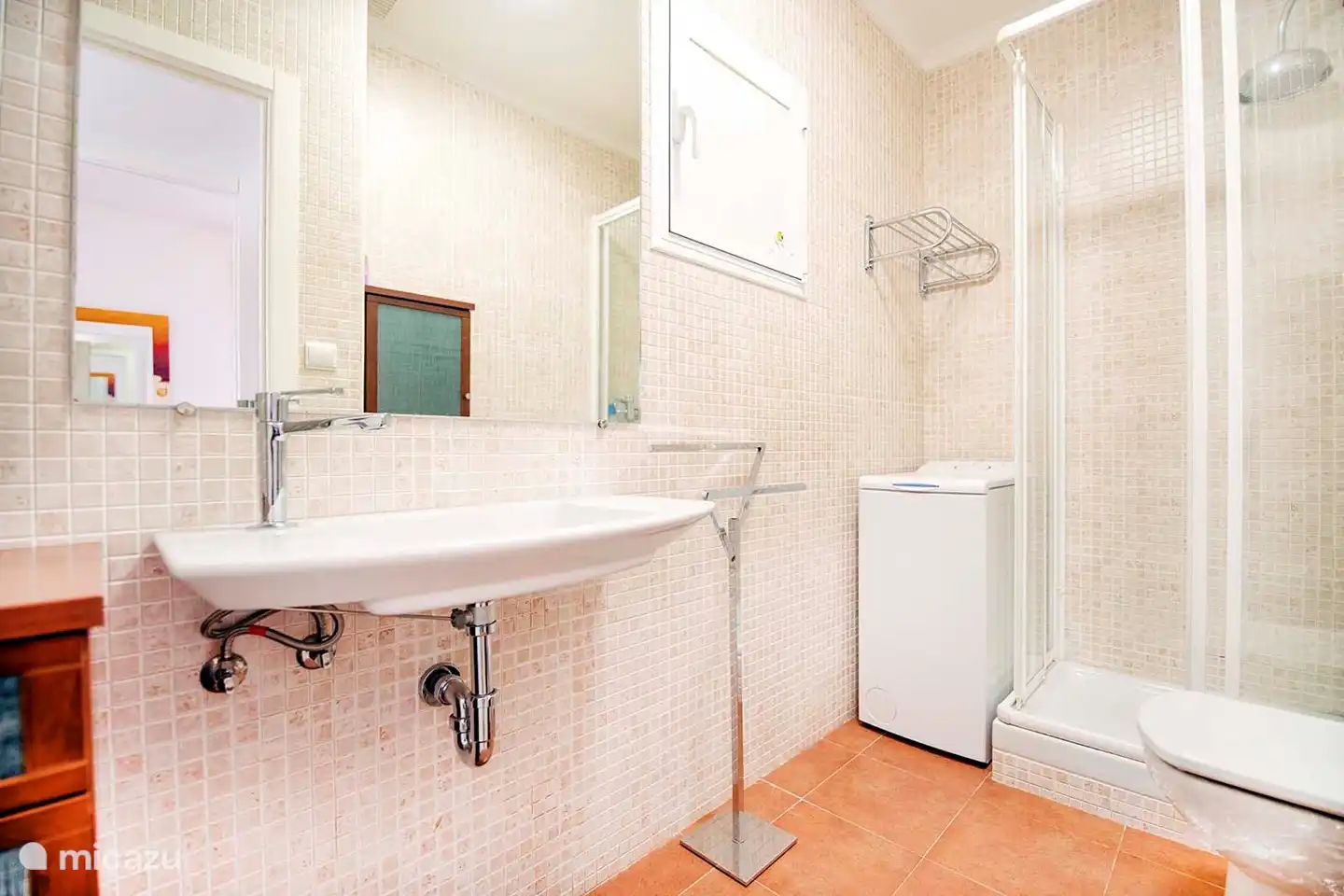 Badezimmer mit Waschbecken, Toilette, Dusche und Toplader-Waschmaschine