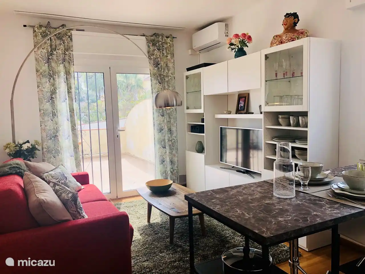 Kleiner, aber komfortabler Wohnraum mit offener Küche und Zugang zur großen Terrasse.