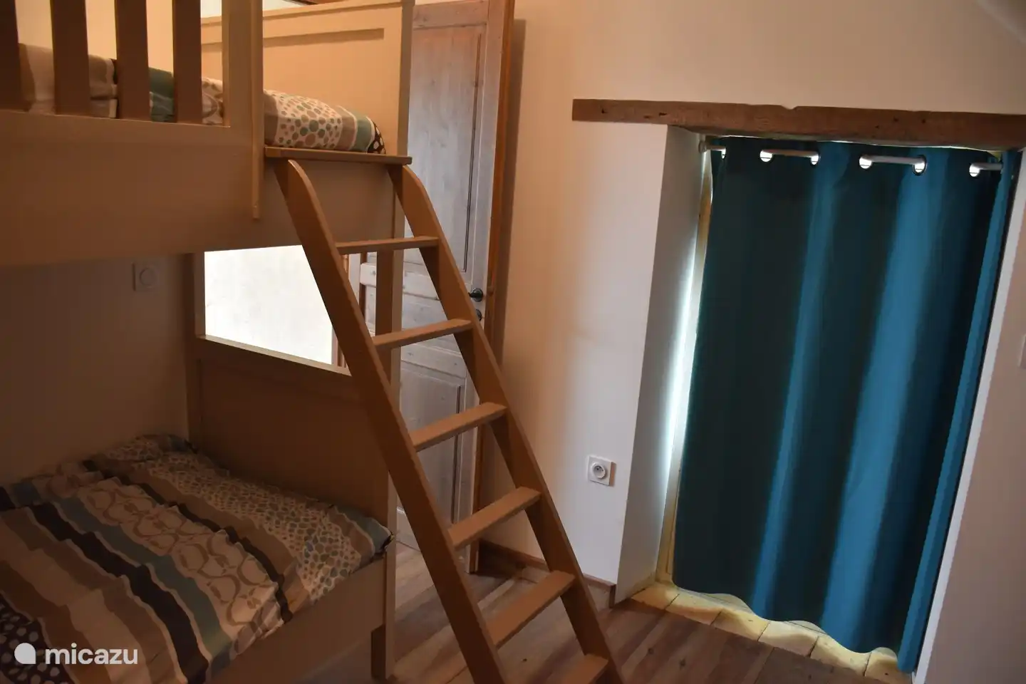 Chambre avec lits superposés et accès toilettes.