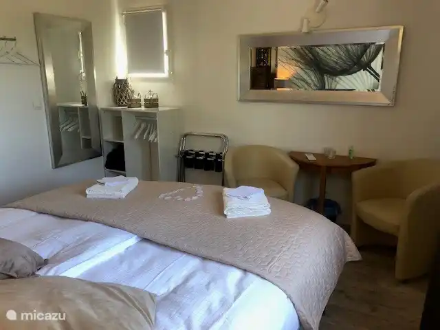 Kingsize-Bett, Sitzecke mit Clubsesseln im Schlafzimmer im Obergeschoss und Klimaanlage