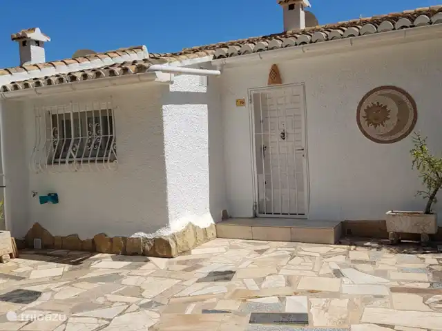 La Trufa | Espagne, Costa Blanca, Moraira - maison de vacances Façade avant (rez-de-chaussée) de La Trufa avec fenêtre de cuisine, porte d'entrée et éclairage extérieur. Stationnement devant la maison.