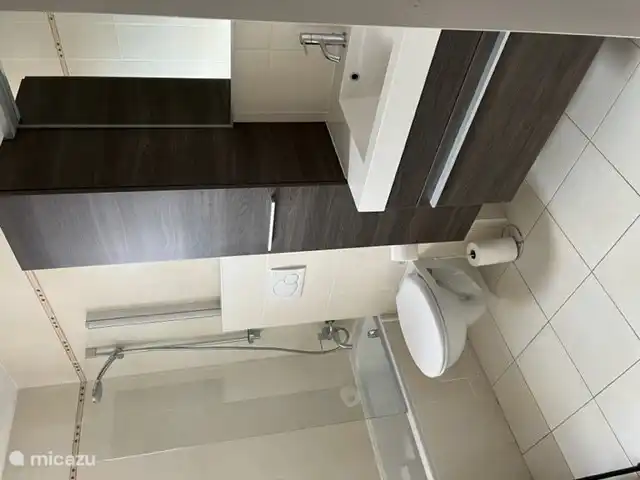 La salle de bain avec baignoire/douche, WC et lavabo.