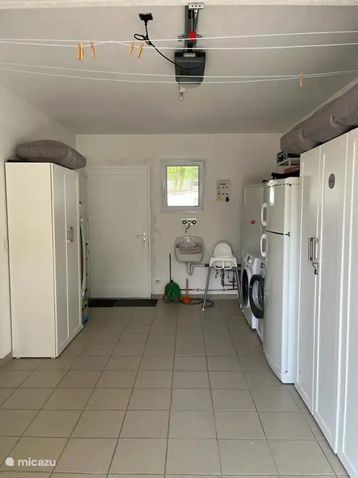 Le débarras avec lave-linge, sèche-linge et réfrigérateur-congélateur.