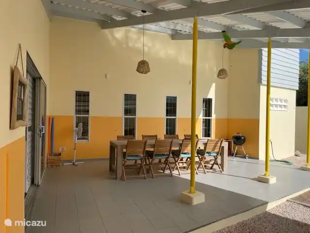 Le grand porche couvert avec une table à manger très spacieuse. 