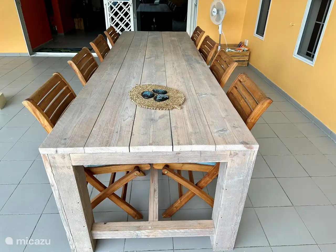 Il y a une belle grande table à manger et un ventilateur. 