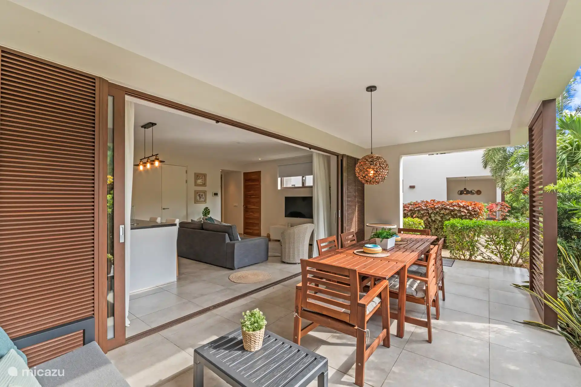 Salon qui se jette harmonieusement dans la terrasse grâce aux portes coulissantes.