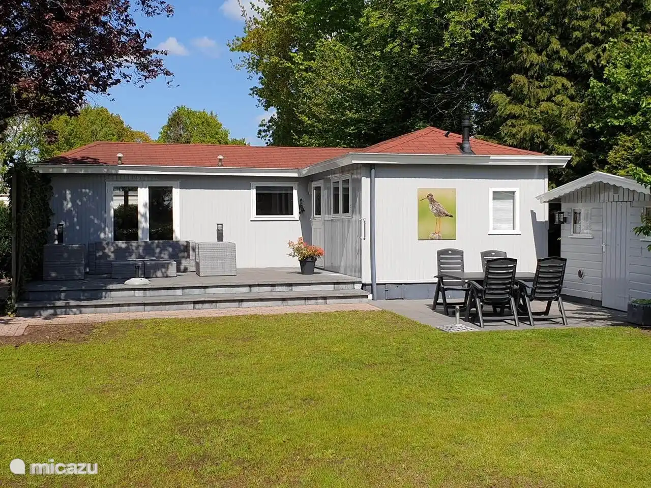 Terrasse mit Lounge-Sofa und Stühlen und Sonne den ganzen Tag.