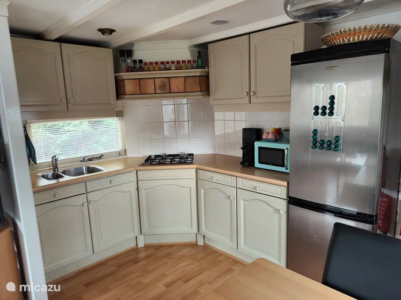 Raumoffene Küche mit großem Kühl- und Gefrierschrank, Mikrowelle, Nespresso-Kaffeemaschine, Wasserkocher, Mixer.