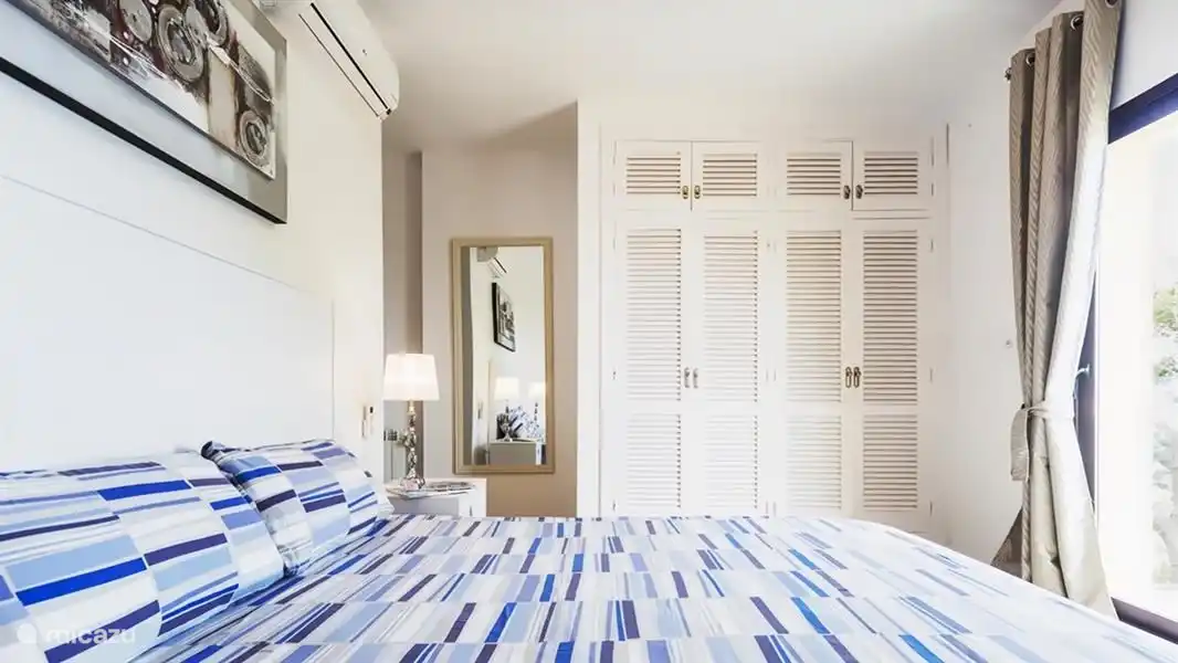 Acogedor dormitorio principal con ropa de cama de alta calidad.