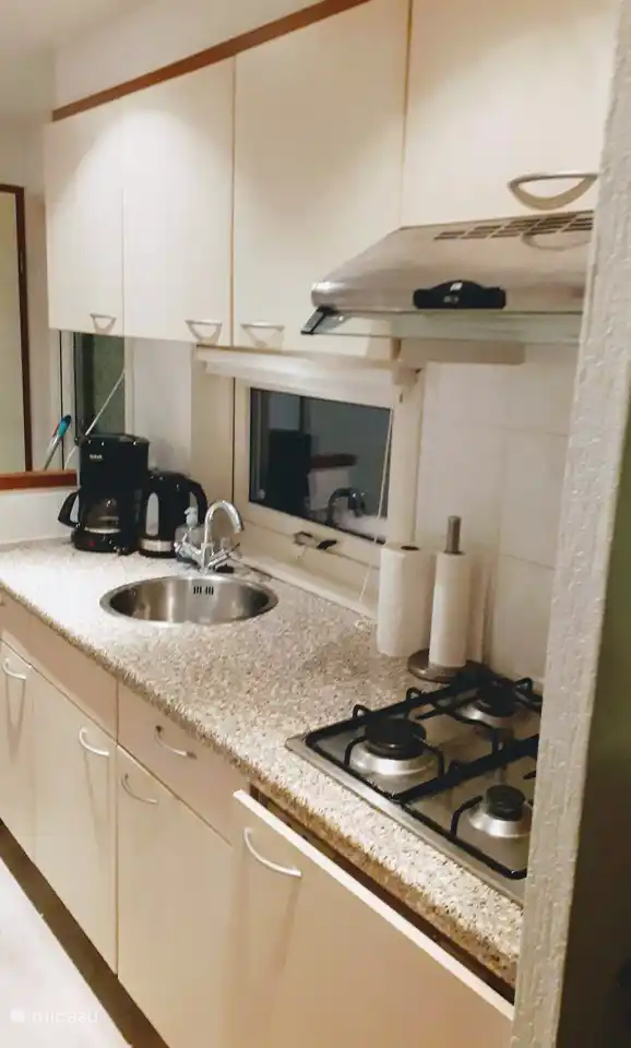 Es gibt eine Küche mit Kühlschrank, Herd, Dunstabzugshaube, Kaffeemaschine, Senseo und Wasserkocher.