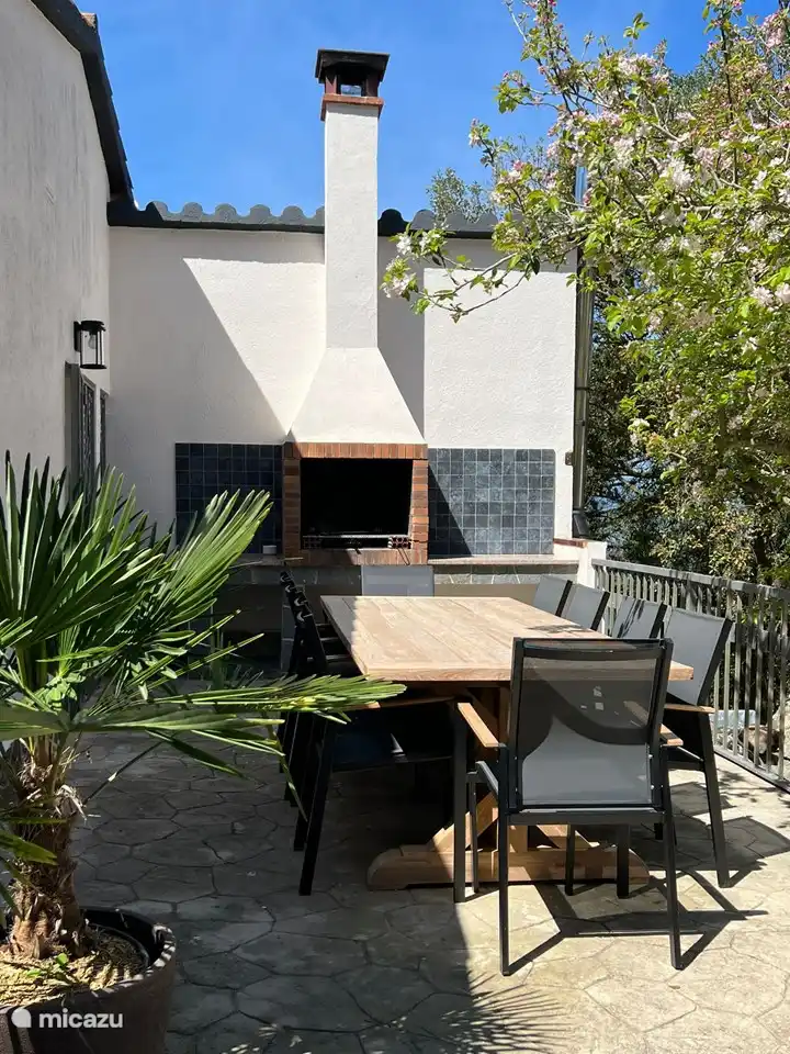 Terraza con barbacoa española en la parte trasera