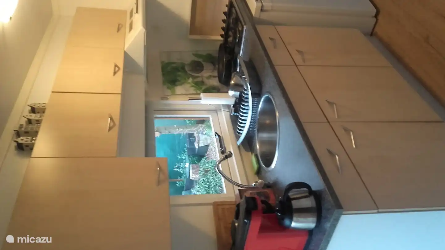 Die Küche hat einen offenen Charakter und ist mit dem Wohnzimmer verbunden. Die Dunstabzugshaube sorgt dafür, dass Kochgerüche entfernt werden.