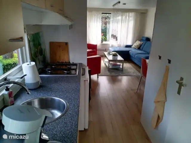 Location de Vacances Pays-Bas, Gueldre, Doornspijk, chalet - Chalet J8 c'est ainsi que vous regardez le salon depuis la cuisine avec réfrigérateur en chêne et cuisinière à quatre feux.