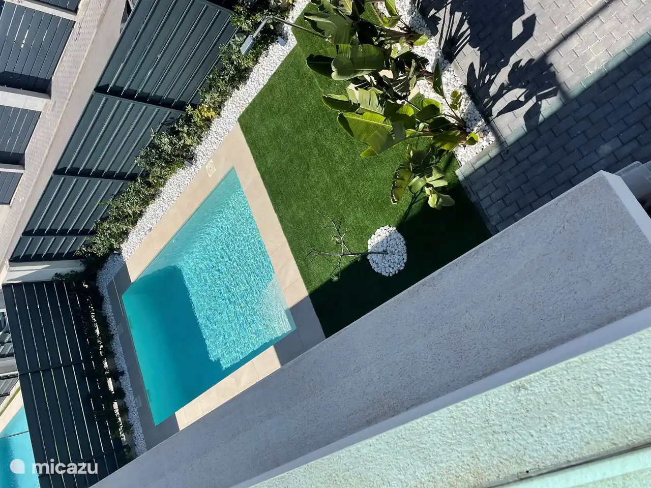 Piscine privée avec gazon (artificiel) et douche extérieure.