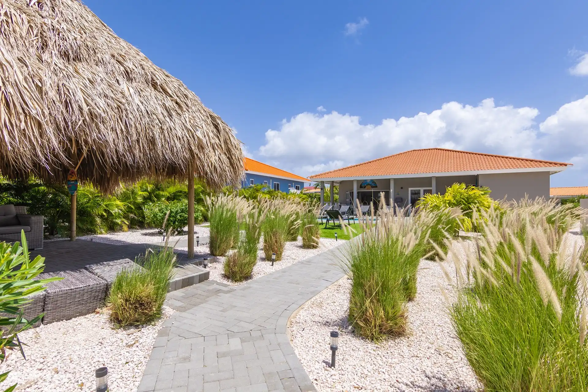 Villa Nisa - view from the parking lot towards the garden and the villa, with the palapa on the left.