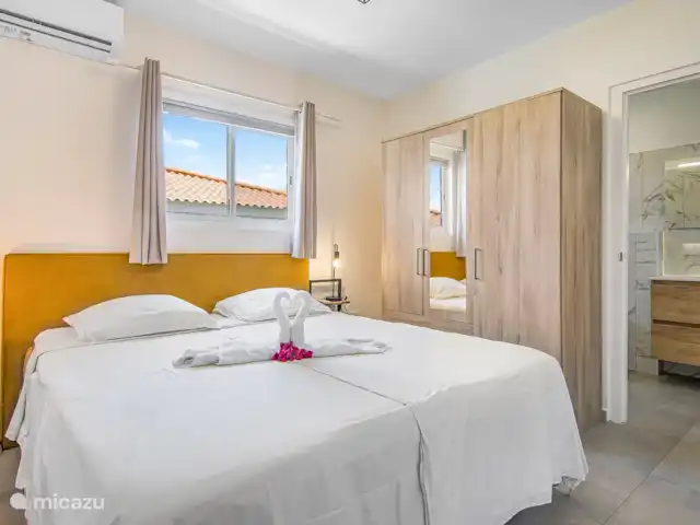 Villa Nisa - Home of Ease | Curaçao, Banda Abou (ouest), Fontein - villa Villa Nisa - chambre avec vue sur le côté de la villa avec un sommier tapissier de 180x210cm et une salle de bain attenante.