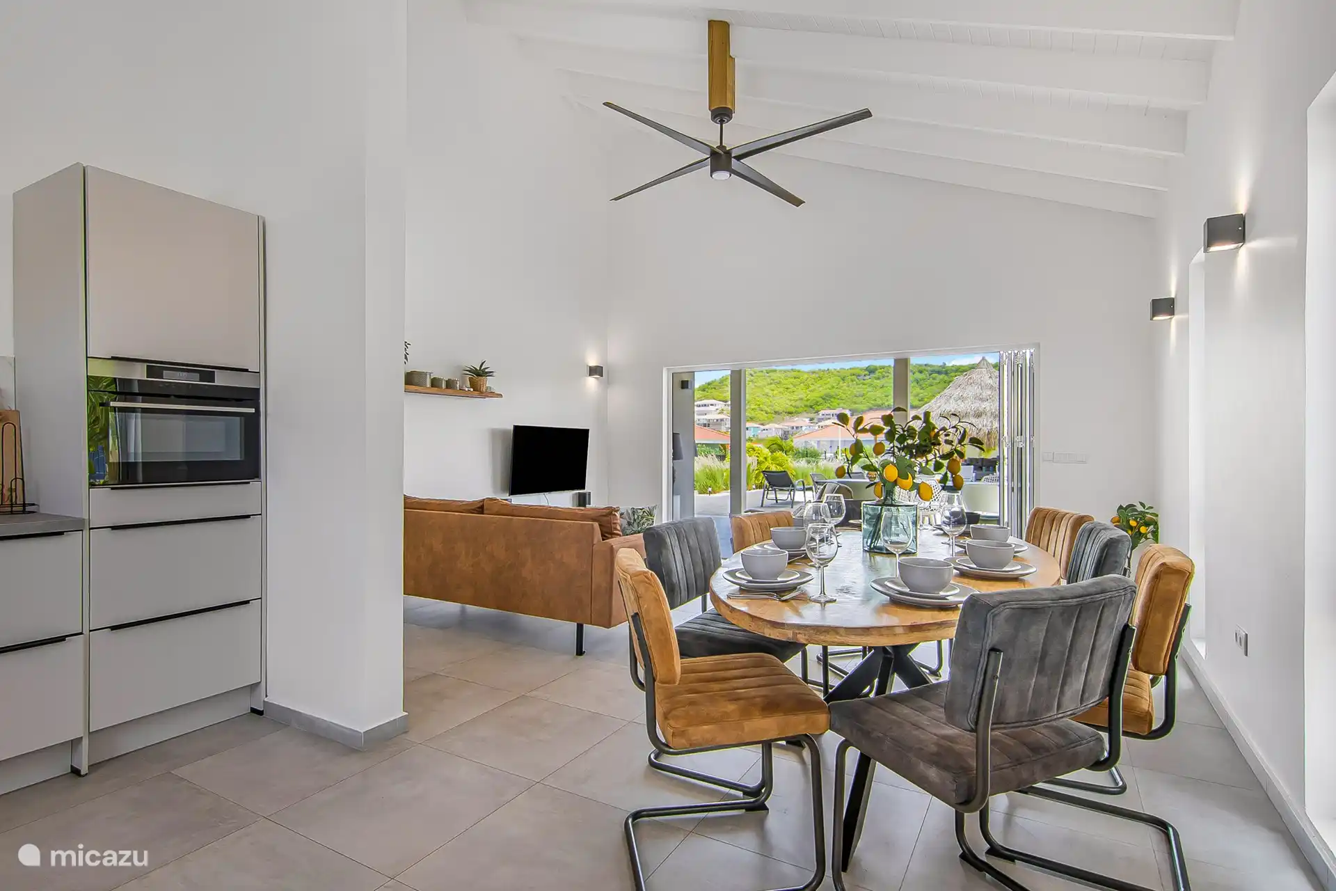 Villa Nisa - view dining table towards the living room, porch and pool