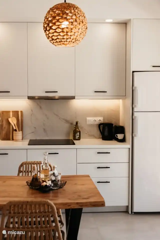 Dunstabzugshaube, Kochfeld, Kaffeemaschine und Wasserkocher.