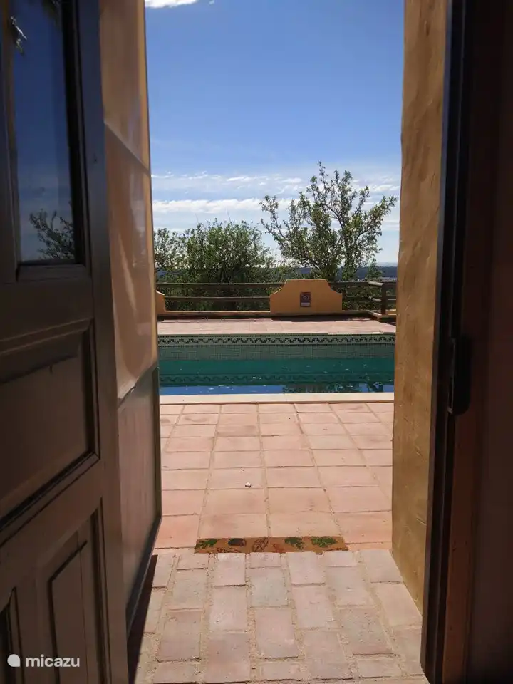 Vista desde la puerta de la cocina a la piscina y al mar.