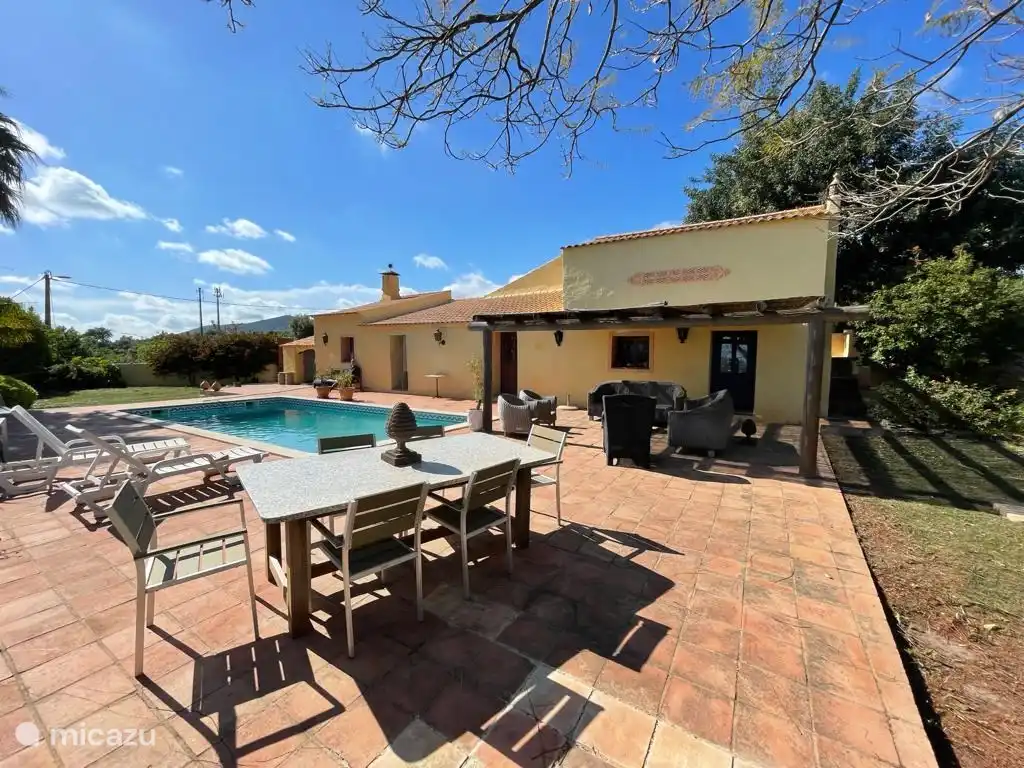 Vista lateral de la casa con varias áreas para sentarse.