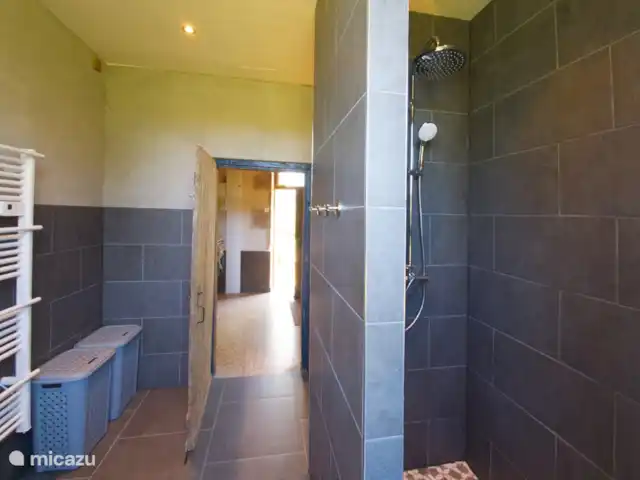Casa de vacaciones Laume en Francia, Allier, Theneuille - casa vacacional El cuarto de baño con ducha a ras de suelo y el aseo a la izquierda. en la planta baja. El pasillo es visible a través de la puerta.