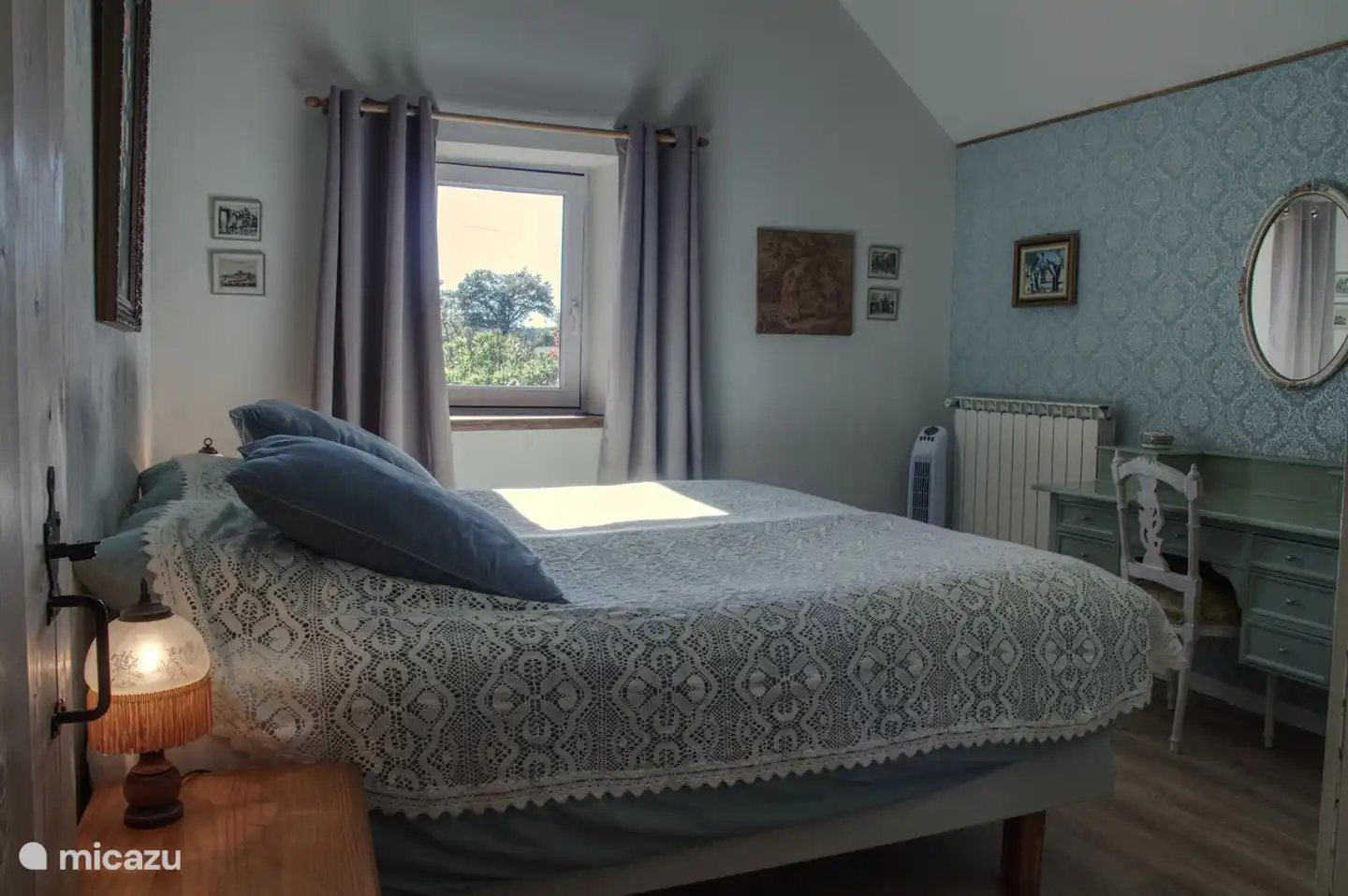 Das blaue Schlafzimmer mit Schminktisch und Blick in den Garten