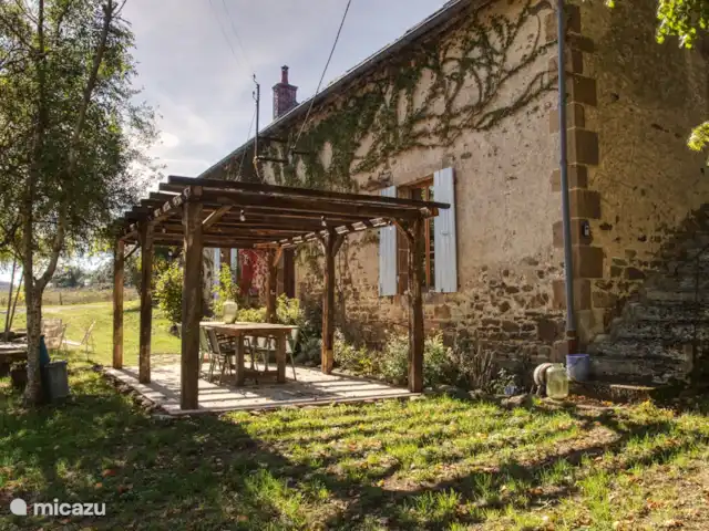 Casa de vacaciones Laume en Francia, Allier, Theneuille - casa vacacional La terraza en frente de la casa con la mesa del comedor. Desde esta terraza tiene una vista amplia de todo el jardín delantero con piscina.