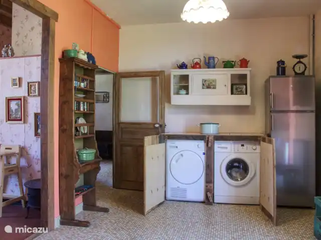 Casa de vacaciones Laume en Francia, Allier, Theneuille - casa vacacional La puerta de la cocina de la cocina al pasillo. El comedor es visible a la izquierda. La lavadora y la secadora se encuentran en la cocina.