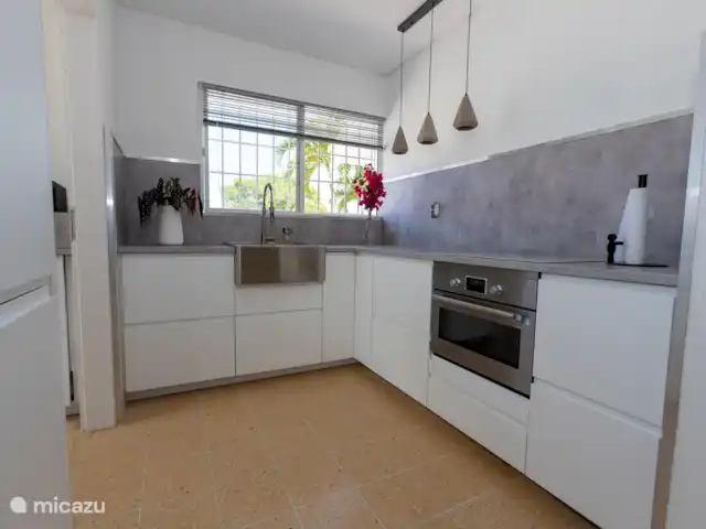 Paradis tropical avec piscine privée | Curaçao, Banda Abou (ouest), Big Mountain - bungalow La cuisine est équipée d'une plaque à induction, d'un four micro-ondes combiné, de 2 réfrigérateurs-congélateurs pour beaucoup d'espace de refroidissement, d'un évier et d'un lave-vaisselle et d'un lave-linge dans le garde-manger