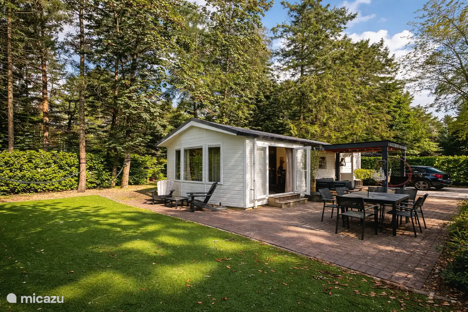 Ruime tuin rondom en auto naast het huisje