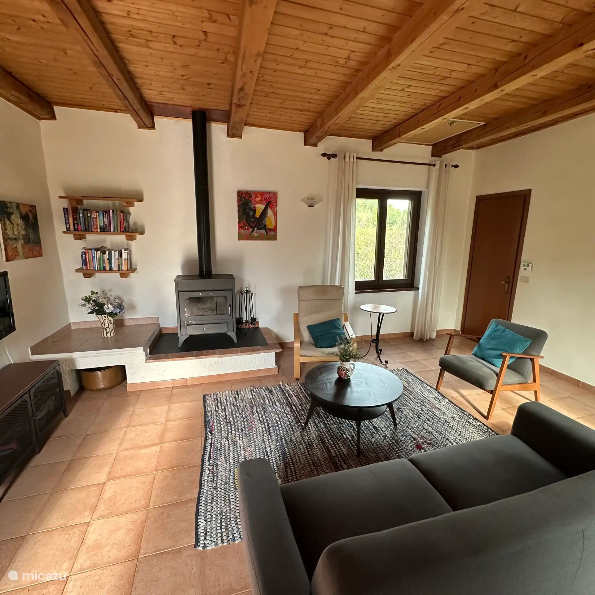 Le vaste salon avec vue sur le jardin, une piscine et un oliverai de l’autre côté. 