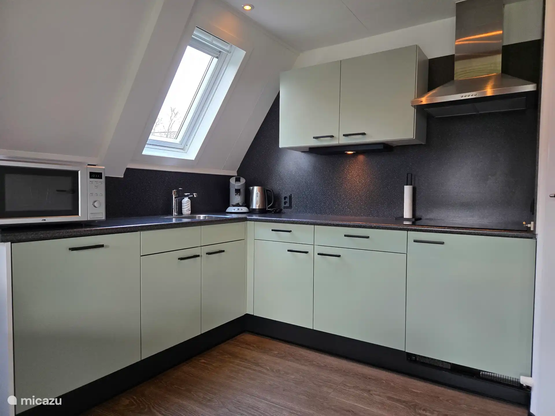 De keuken, voorzien van combi magnetron/oven, vaatwasser, Senseo, filterkoffiezetapparaat, waterkoker, inductie kookplaat en koelkast met klein vriesvakje