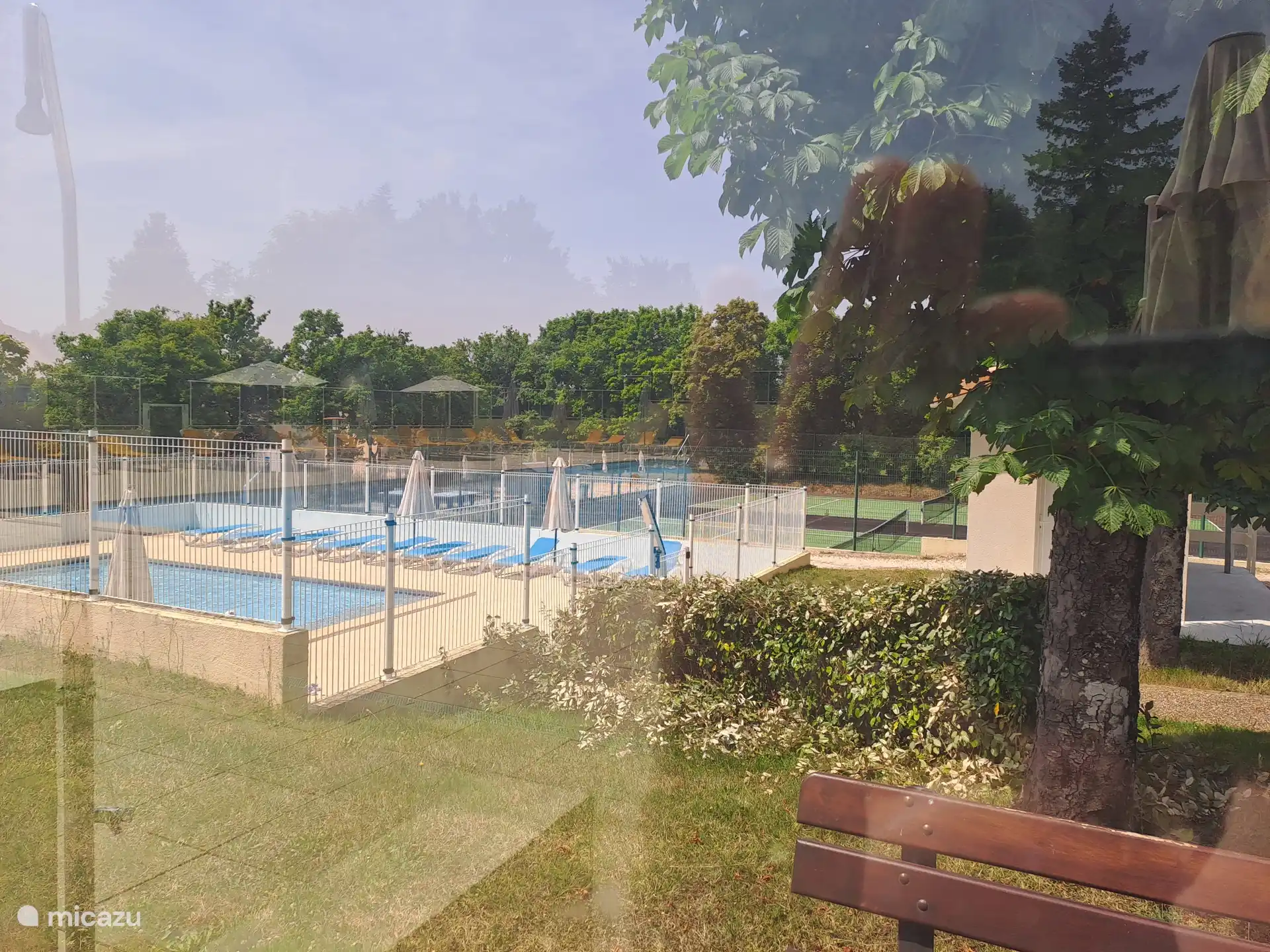 Zwembad met tevens omheind peuterbad met ligbedden en parasols 