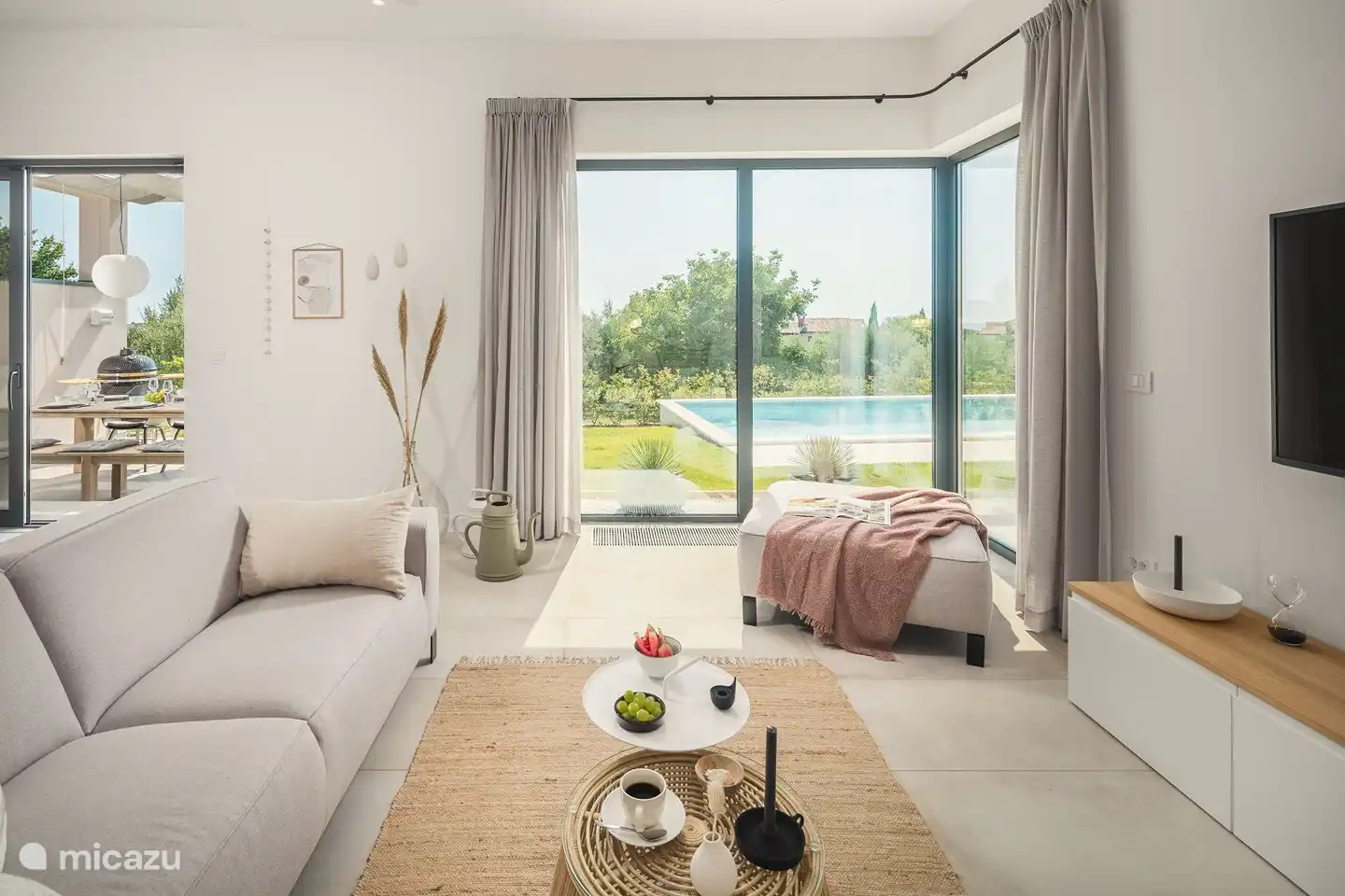 Atmosphärisches Wohnzimmer mit Blick auf den Garten und den privaten Pool.