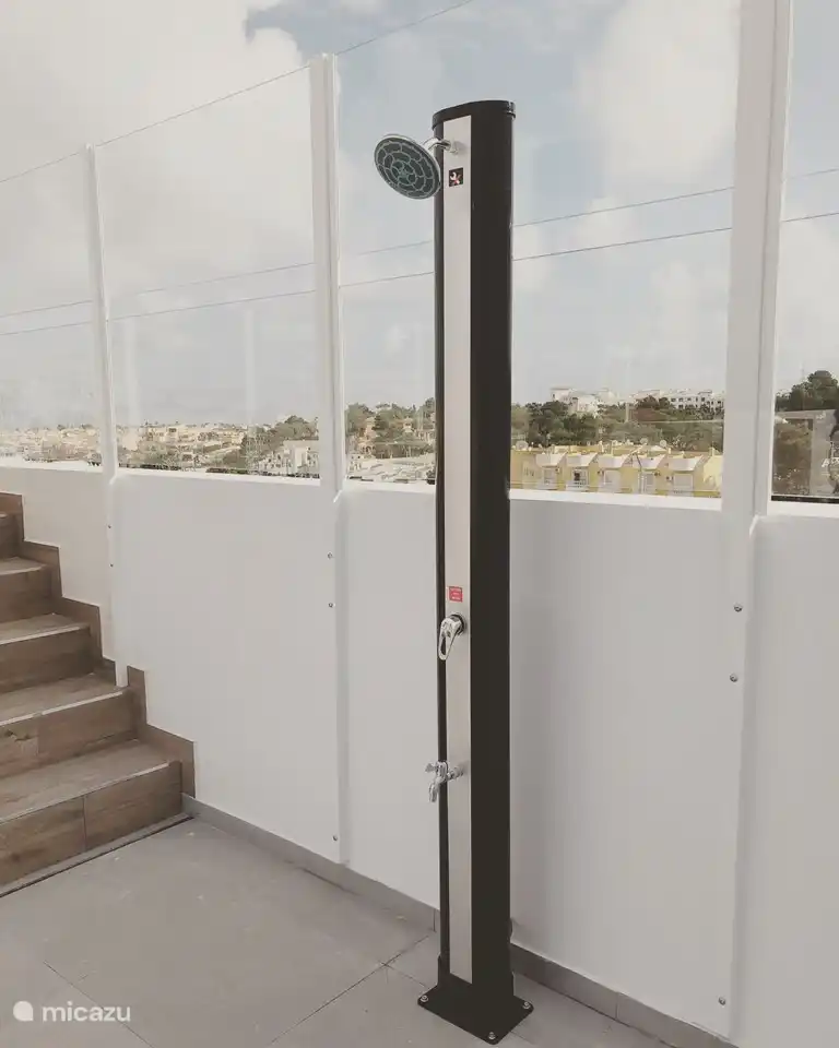 Ducha exterior en piscina comunitaria