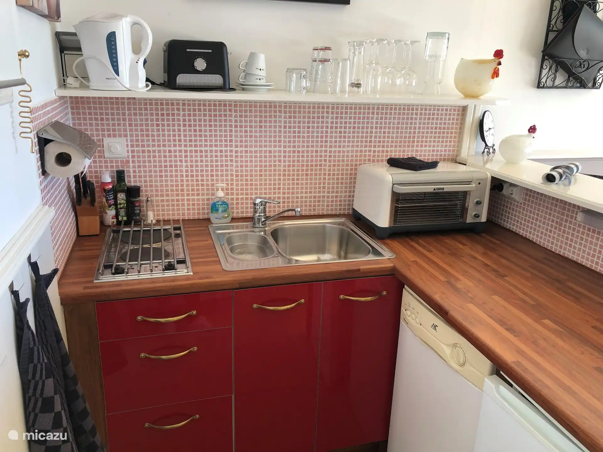 Küchenzeile mit Nespresso-Maschine, Herd, Kühlschrank, Backofen, Toaster, Geschirrspüler, Tellern, Besteck, Wasserkocher, Gläsern etc  