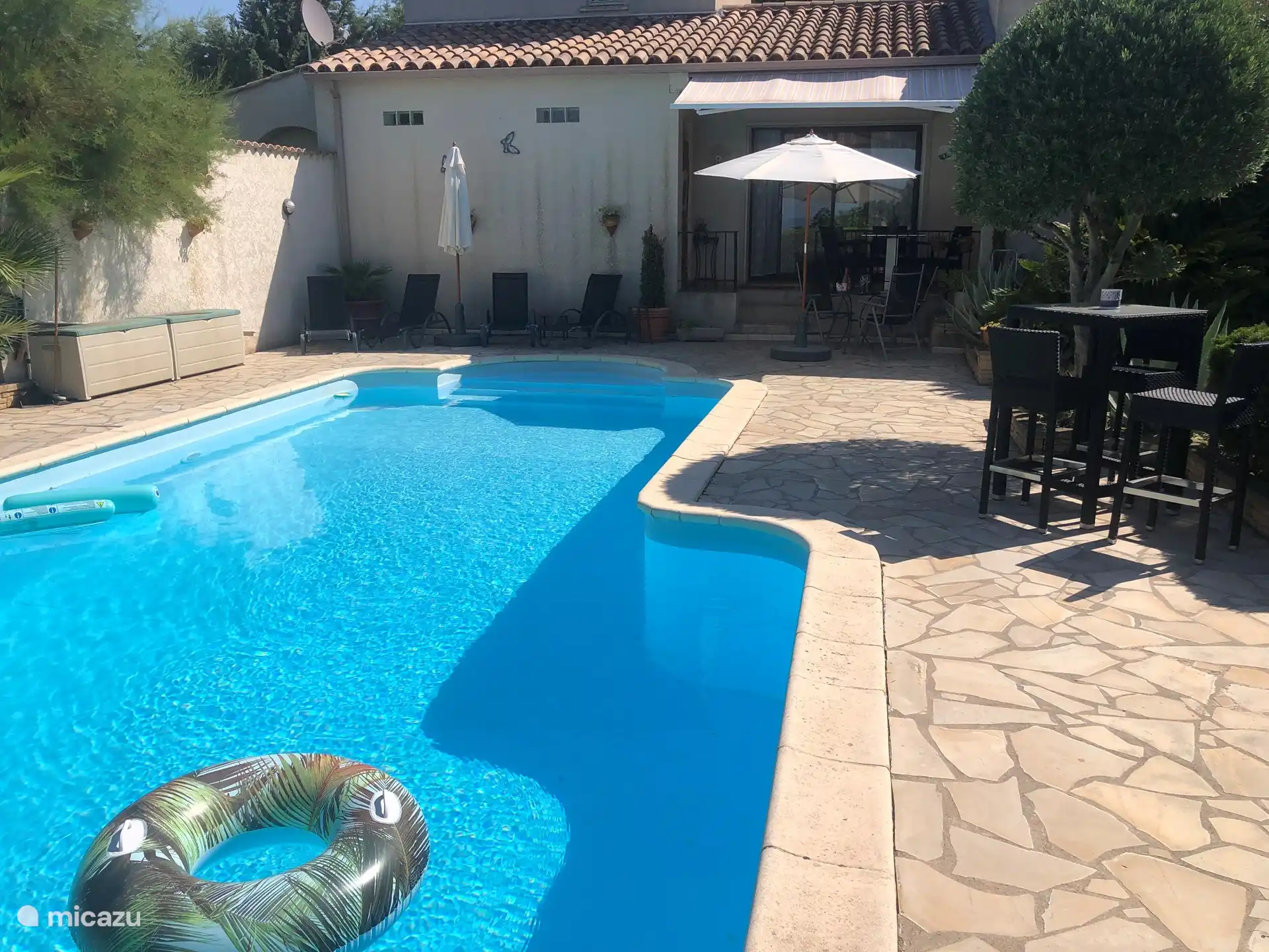 Rund um das Schwimmbad gibt es Sitzgelegenheiten, auf denen Sie sich entspannen können