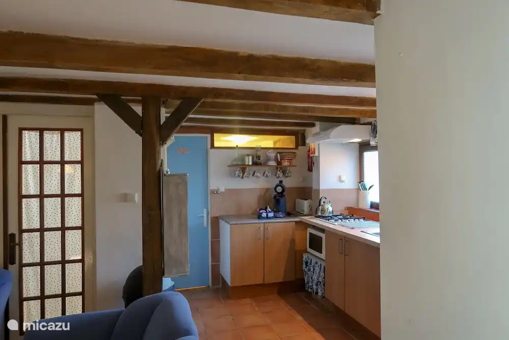 offene Küche mit Spülmaschine. Hinter der blauen Tür befindet sich ein weiteres Waschbecken, eine Toilette und eine Waschmaschine