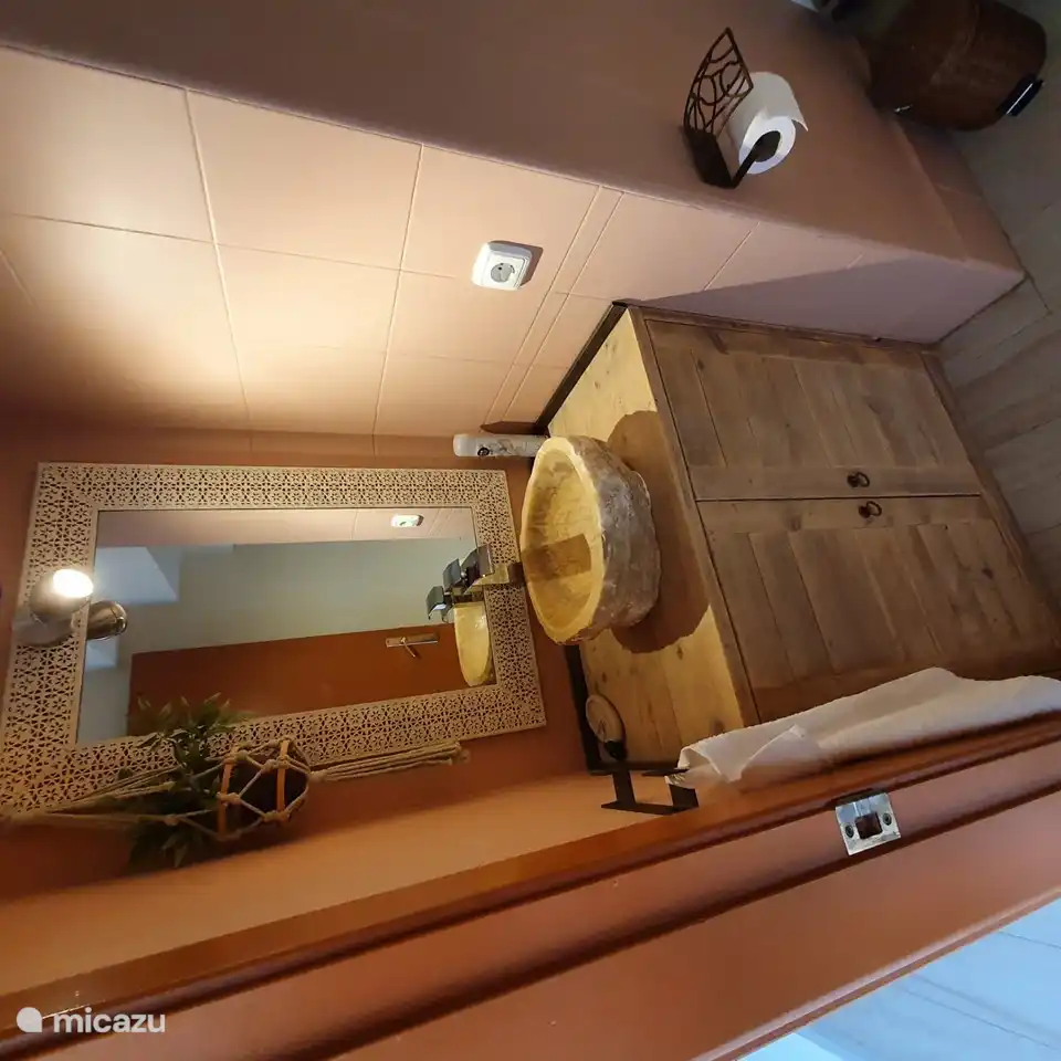 toilet with sink located between the living room and kitchen