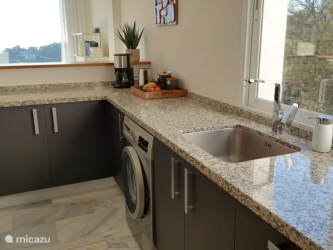 in der Küche mit Blick auf das Meer und den grünen Garten mit Swimmingpool