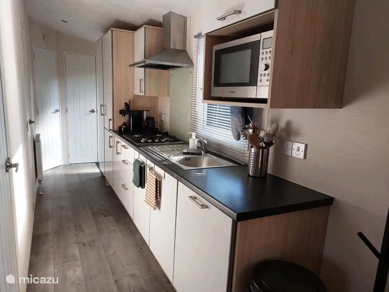 Die Küche verfügt über einen Geschirrspüler, eine Kombi-Mikrowelle, einen 4-Flammen-Gasherd, einen geräumigen Kühlschrank mit Gefrierfach, einen Wasserkocher, einen Senseo-Schalter und Stauraum für Lebensmittel.