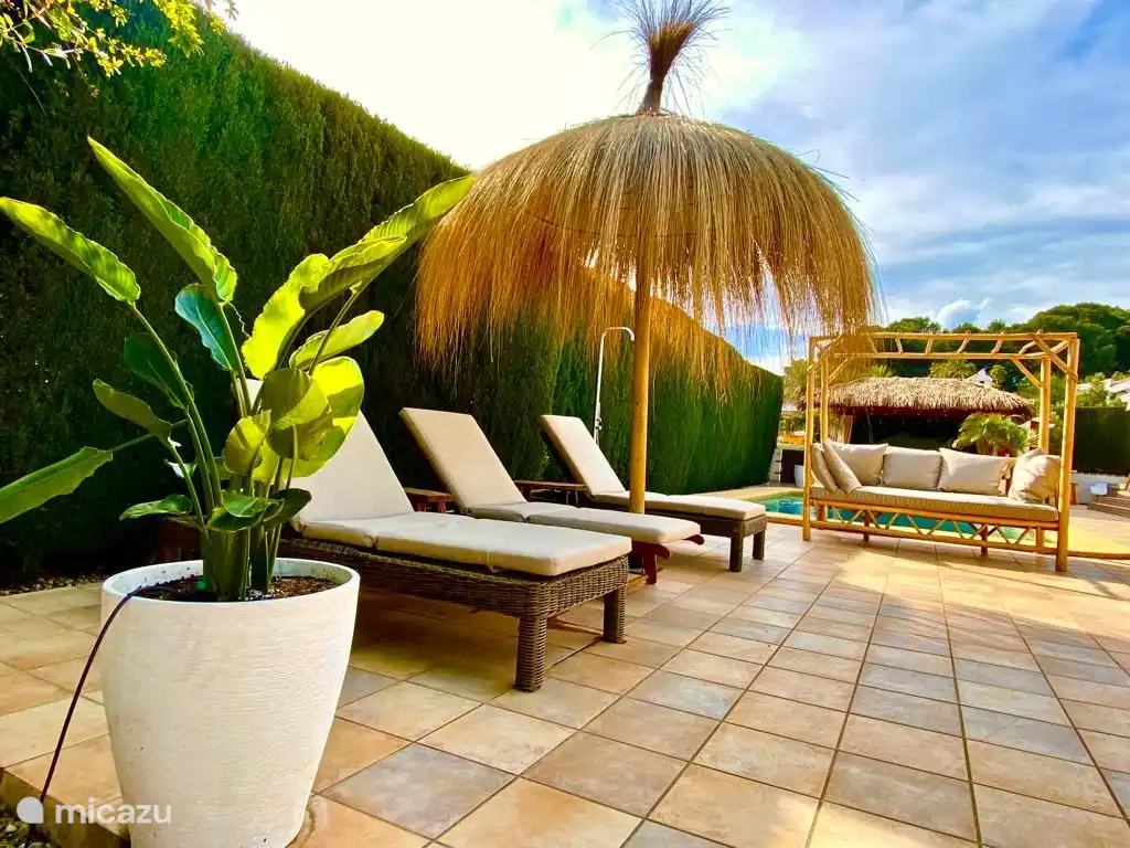 Geräumige bequeme Sonnenliegen unter den tropischen Sonnenschirmen.