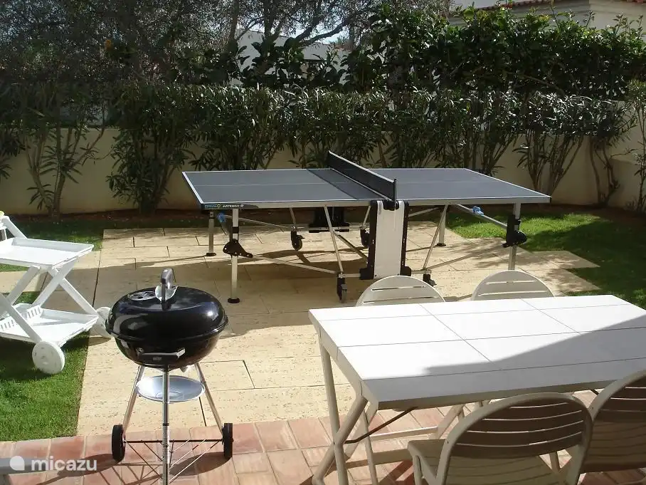 De tuin heeft ruime terrassen met een outdoor tafeltennistafel, barbecue, tuintafel en serveerwagen.