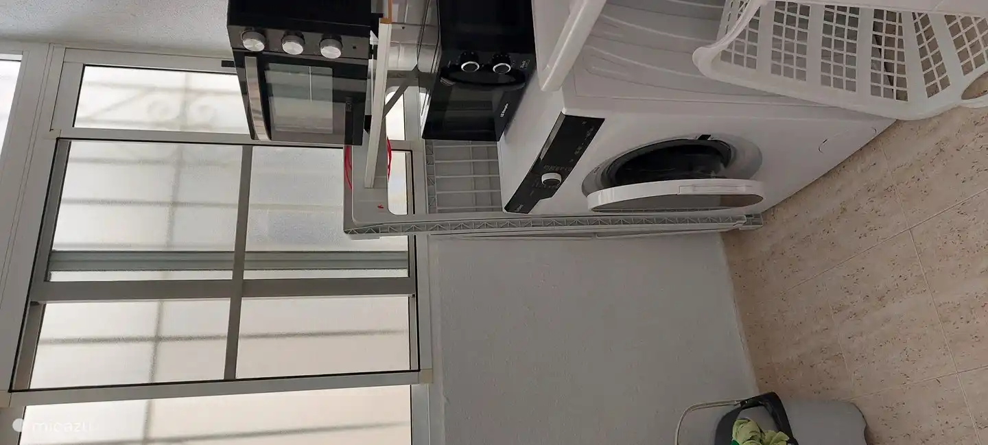 Hauswirtschafts-/Waschküche mit Waschmaschine, Backofen und Mikrowelle