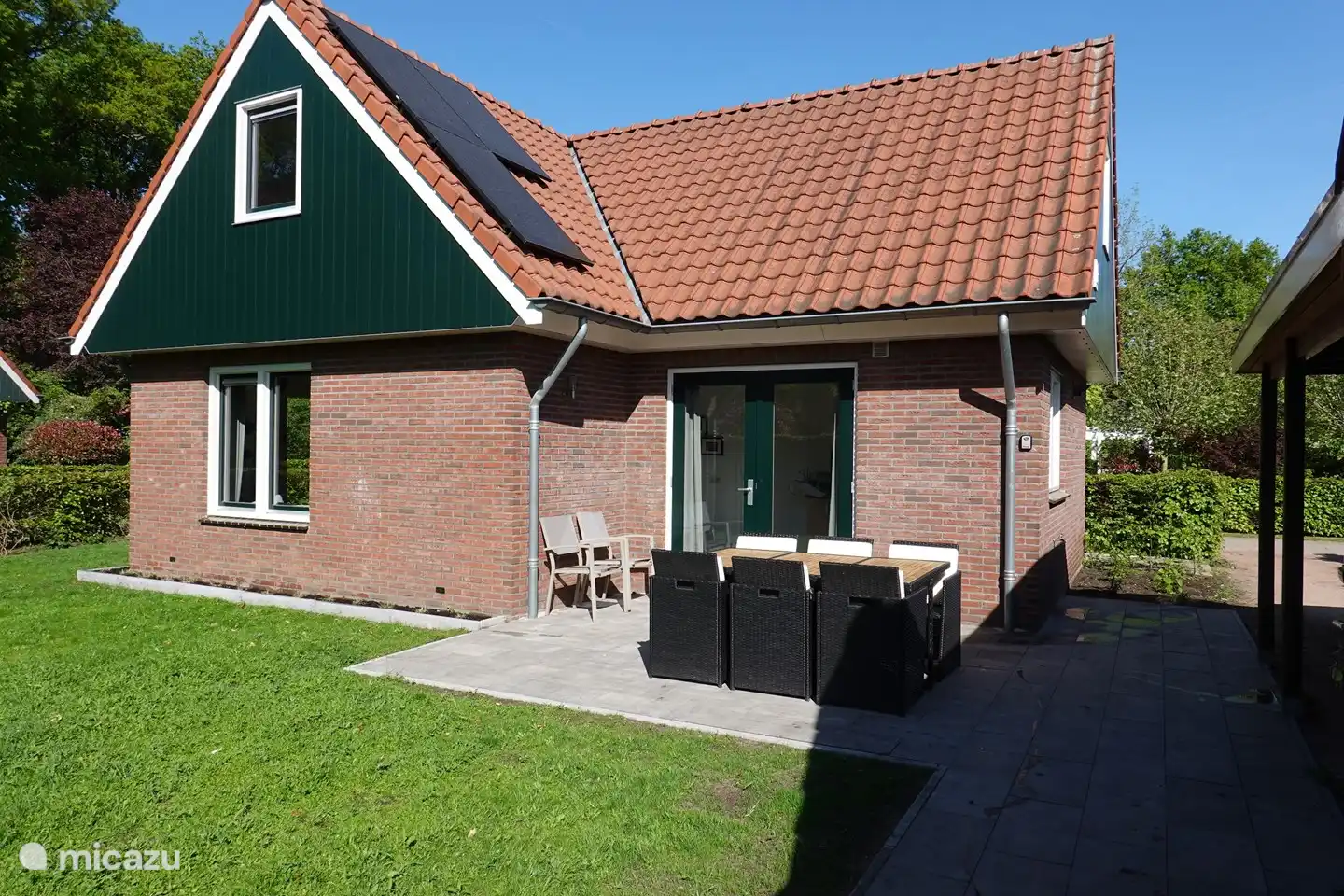 Un jardin spacieux avec une terrasse ensoleillée