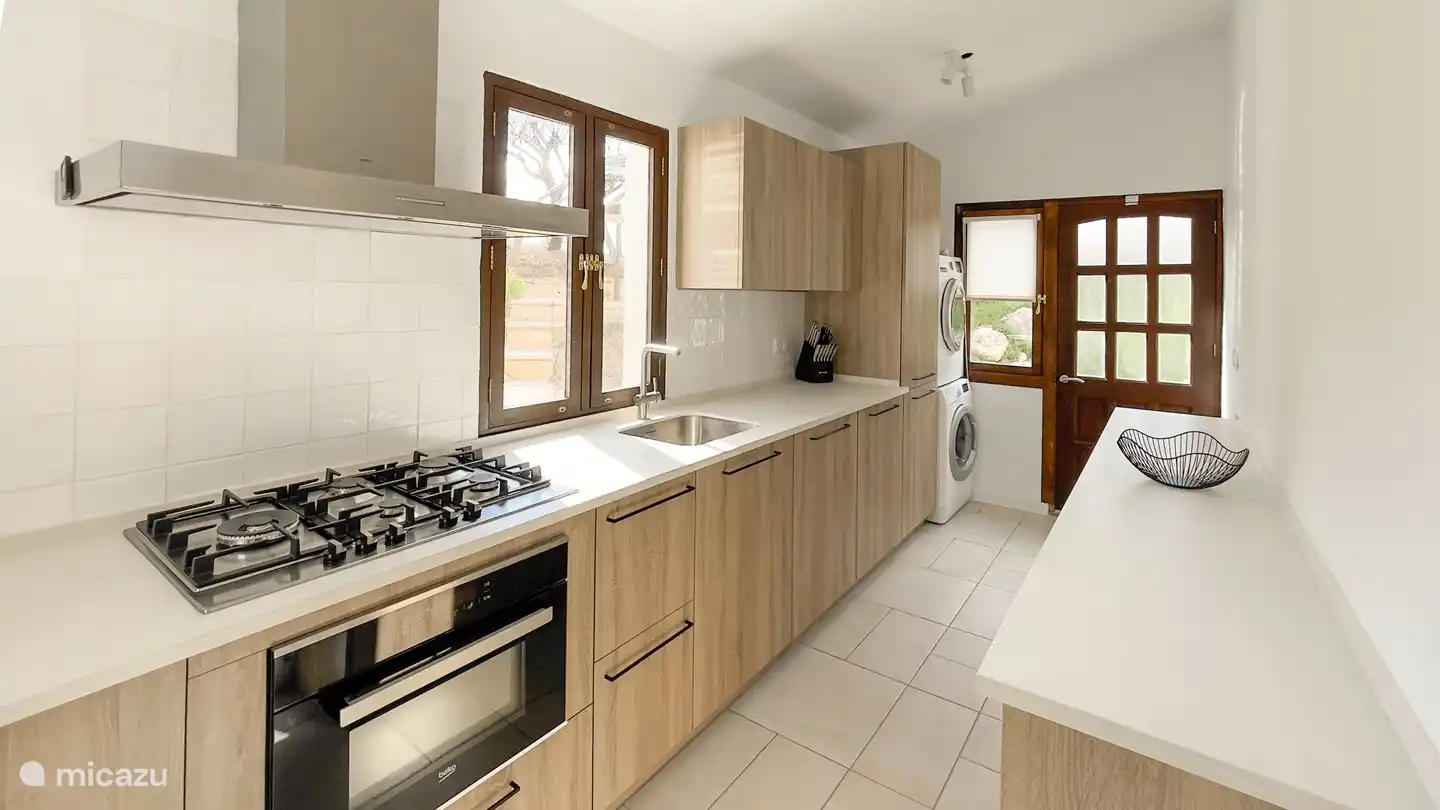 Cocina totalmente equipada con cocina a gas, horno combi, nevera-congelador, lavadora y secadora