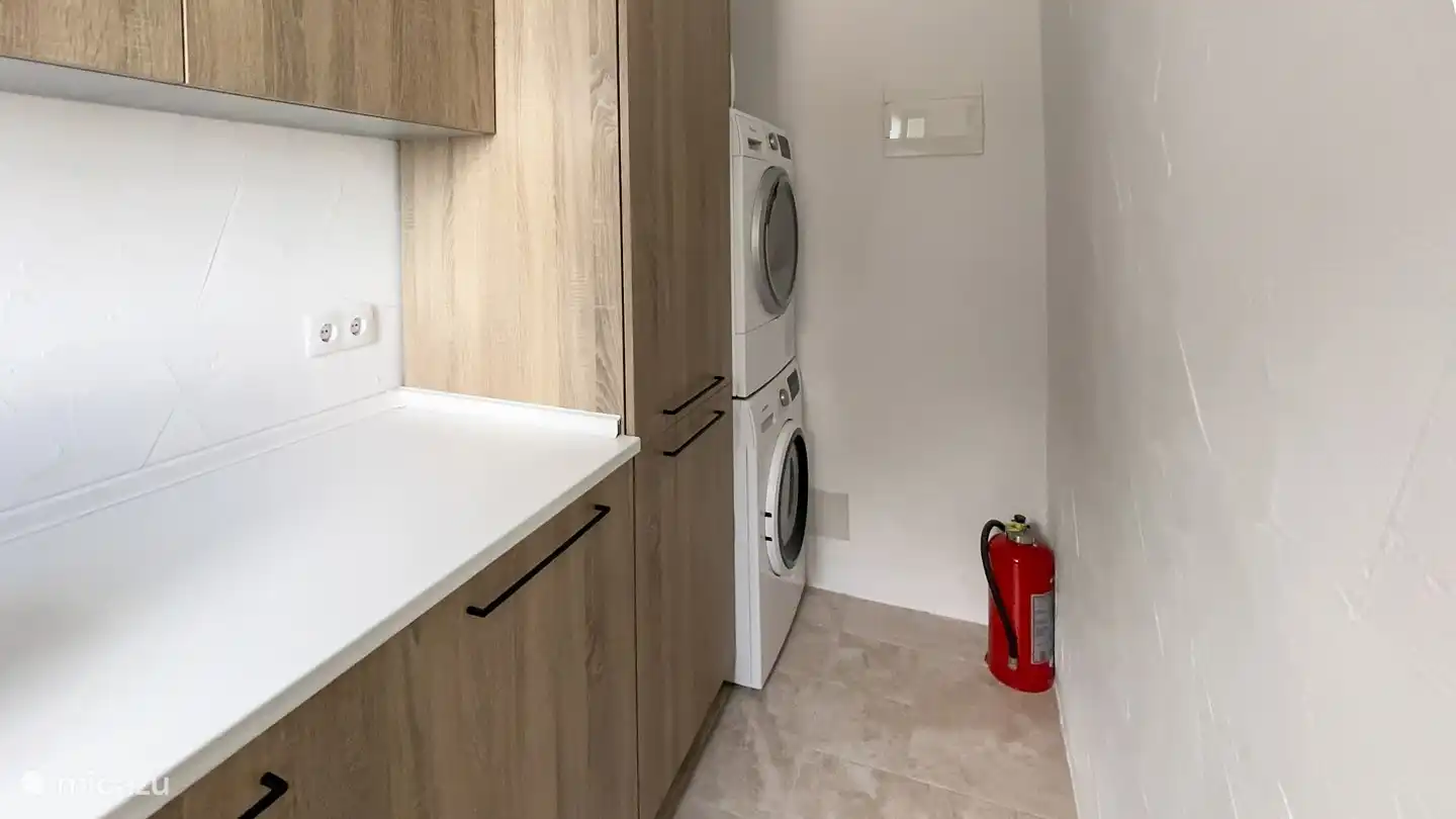 Lavadero con lavadora, secadora y congelador